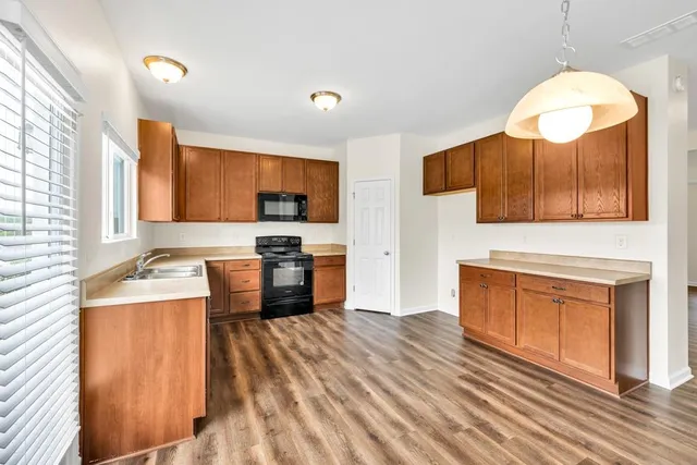 a kitchen with stainless steel appliances granite countertop a stove a sink and a microwave