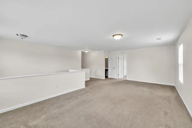 an empty room with windows and mirror