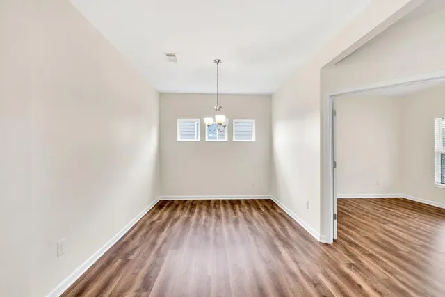 a view of a bedroom with wooden floor and windows