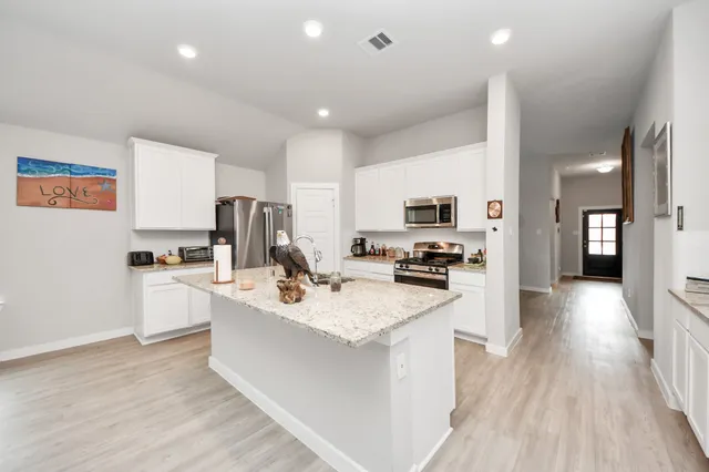 a kitchen with a sink stove cabinets and refrigerator
