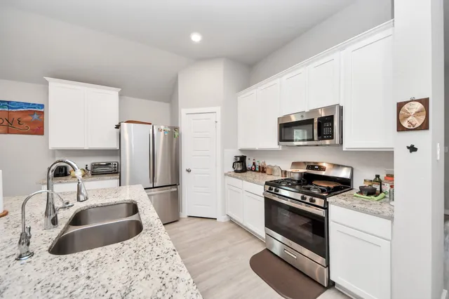 a kitchen with a sink stove and refrigerator