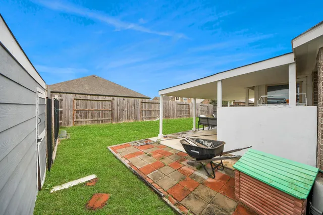 a view of a backyard with table and chairs with wooden fence
