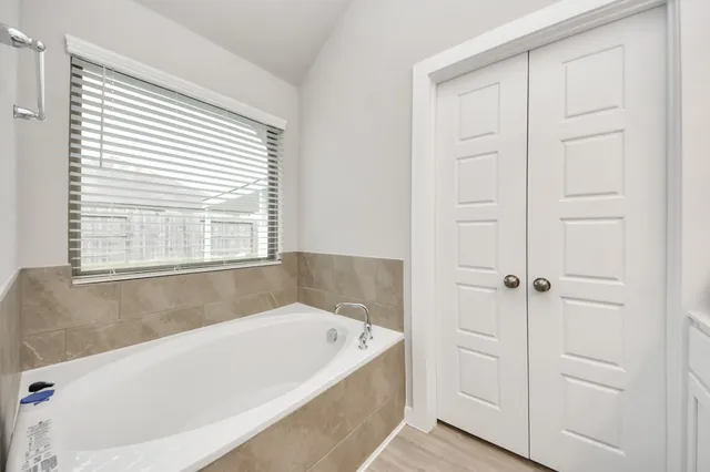 a bathroom with a bathtub and next to a window