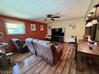 1465 Derby Road Waterford, OH 45786 - Photo 7 of 20 Living room featuring a textured ceiling, hardwood / wood-style floors, and ceiling fan