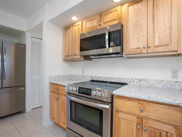 a kitchen with stainless steel appliances granite countertop a stove microwave and refrigerator