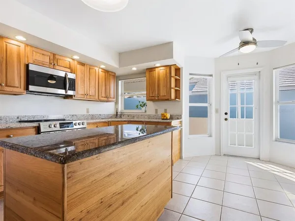 a kitchen with stainless steel appliances granite countertop a stove a sink and a microwave