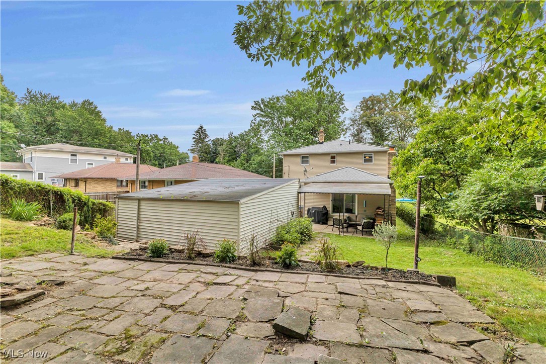 4090 Ridgeview Road Cleveland, OH 44144 - Photo 35 of 40 Back of house featuring a patio, a fenced backyard, a chimney, and an outdoor structure