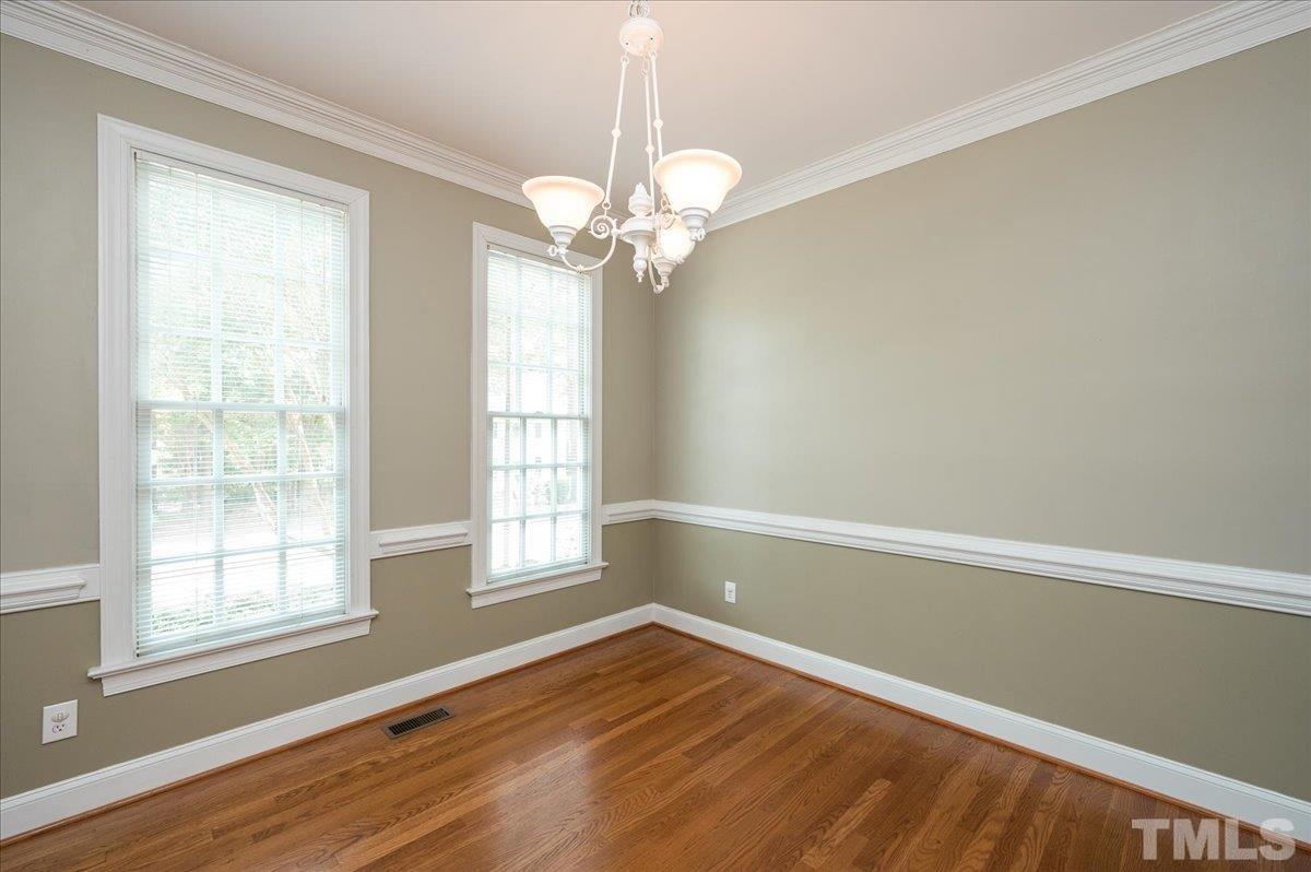 8813 Cottingham Way Raleigh, NC 27615 - Photo 4 of 27 a view of an empty room with a window and wooden floor