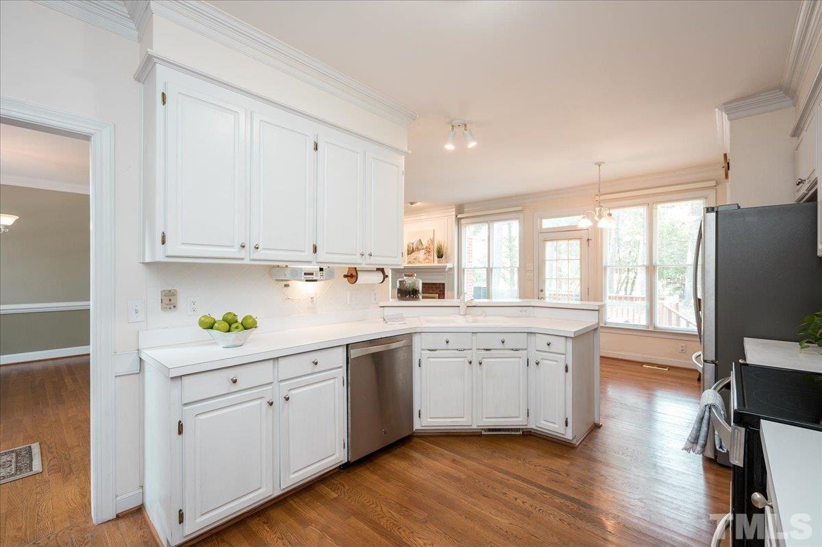 8813 Cottingham Way Raleigh, NC 27615 - Photo 6 of 27 a kitchen with a white cabinets and wooden floor