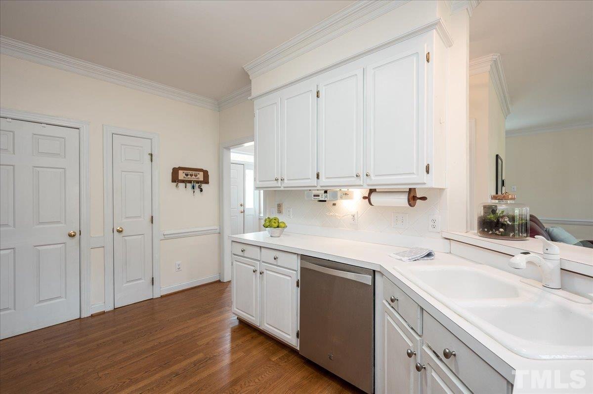 8813 Cottingham Way Raleigh, NC 27615 - Photo 8 of 27 a kitchen with a sink cabinets and wooden floor