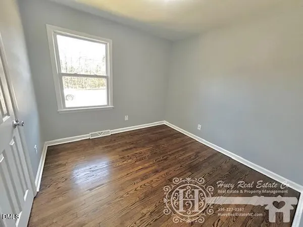 an empty room with wooden floor and window