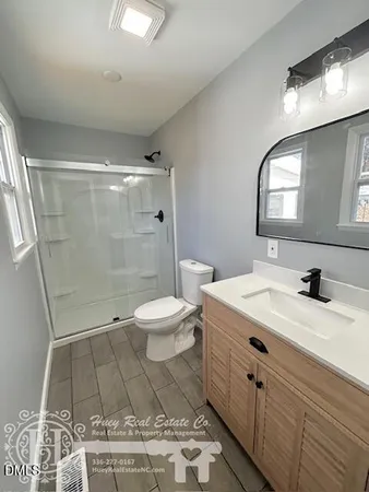 a spacious bathroom with a double vanity sink toilet and a mirror