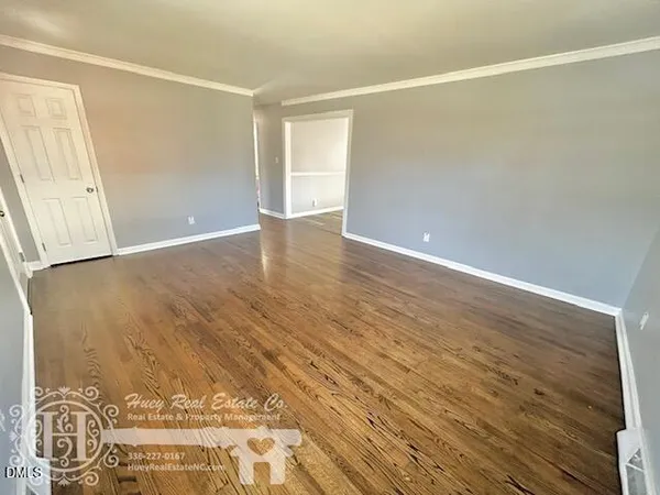 a view of an empty room with wooden floor
