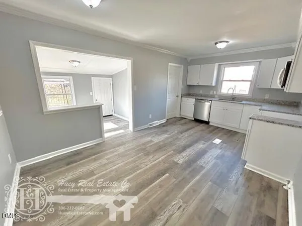 a view of a kitchen with wooden floor and a window