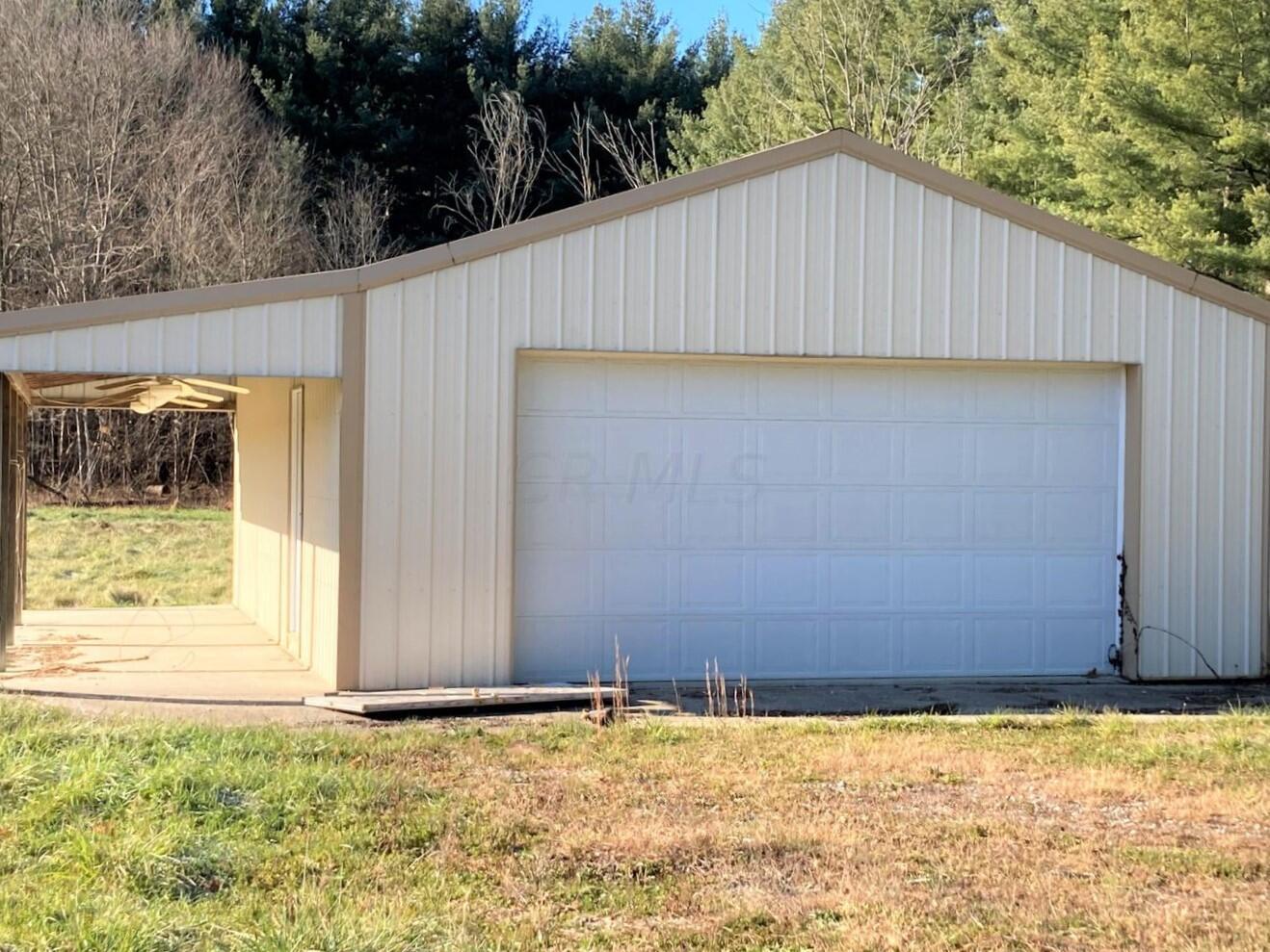 Detached garage with electric, concrete floors, covered side porch with ceiling fans, overhead door.