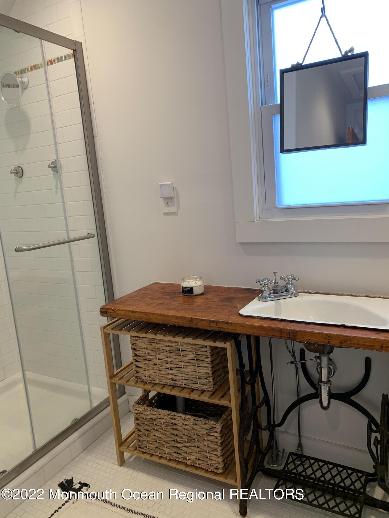 1836 Parkway Belmar, NJ 07719 - Photo 19 of 32 a bathroom with a sink a mirror and a shower