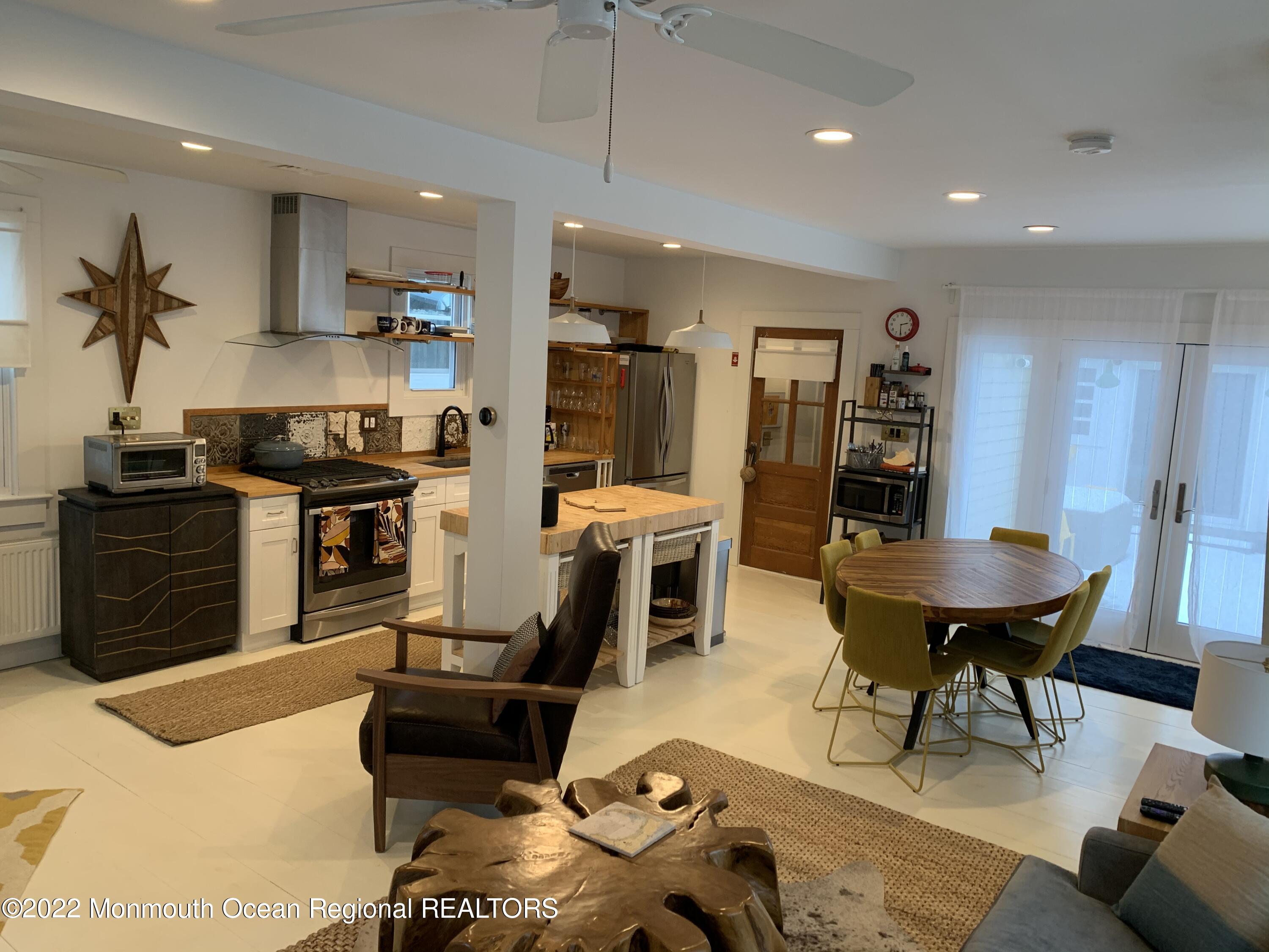 1836 Parkway Lake Como, NJ 07719 - Photo 7 of 32 a kitchen with stainless steel appliances kitchen island granite countertop a refrigerator a stove a sink a dining table and chairs with wooden floor