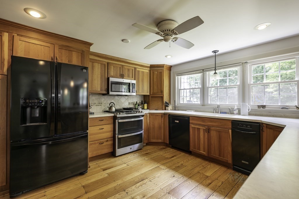 12 West Gill Road Gill, MA 01354 - Photo 17 of 42 a kitchen with stainless steel appliances granite countertop a refrigerator a stove a sink dishwasher a oven with a dining table and chairs