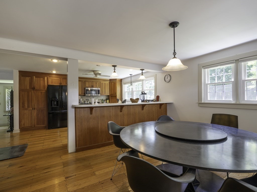 12 West Gill Road Gill, MA 01354 - Photo 19 of 42 a kitchen with stainless steel appliances kitchen island granite countertop a table chairs in it and wooden floors