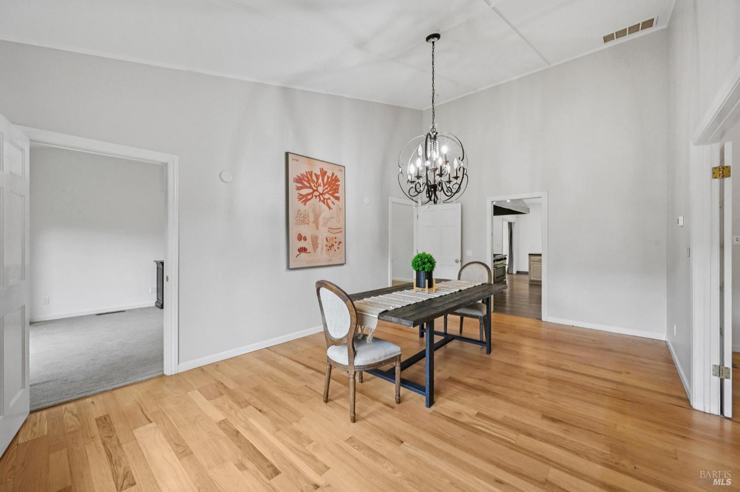 5 Maoli Drive San Rafael, CA 94903 - Photo 22 of 74 a dining room with wooden floor a chandelier a wooden table and chairs
