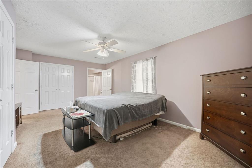 3170 Wages Circle Dacula, GA 30019 - Photo 18 of 39 a spacious bedroom with a bed and a chandelier
