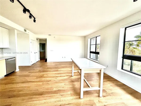 a kitchen with stainless steel appliances a stove a sink and white cabinets with wooden floor