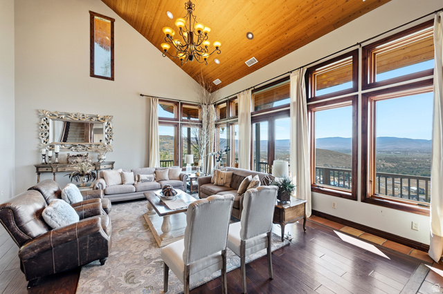 335 Bern Way Midway, UT 84049 - Photo 4 of 88 Spacious living area featuring a vaulted wood-finish ceiling, large picture windows, wood-finish flooring, and a chandelier