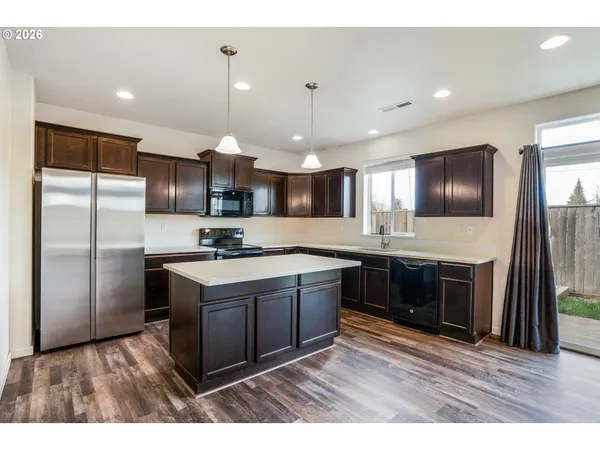 a kitchen with stainless steel appliances granite countertop a stove a sink and a refrigerator