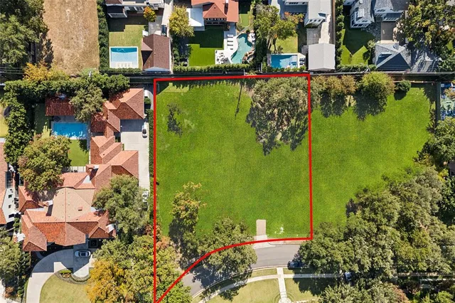 an aerial view of residential houses with outdoor space and trees