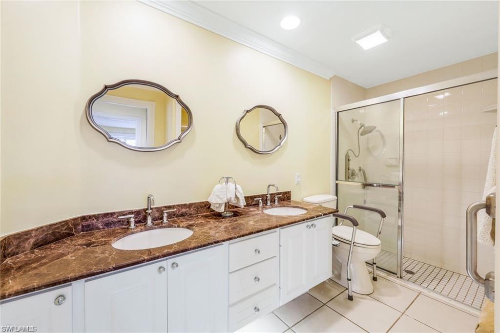 4823 Lasqueti Way Naples, FL 34119 - Photo 10 of 35 a bathroom with a granite countertop double vanity sink mirror and toilet