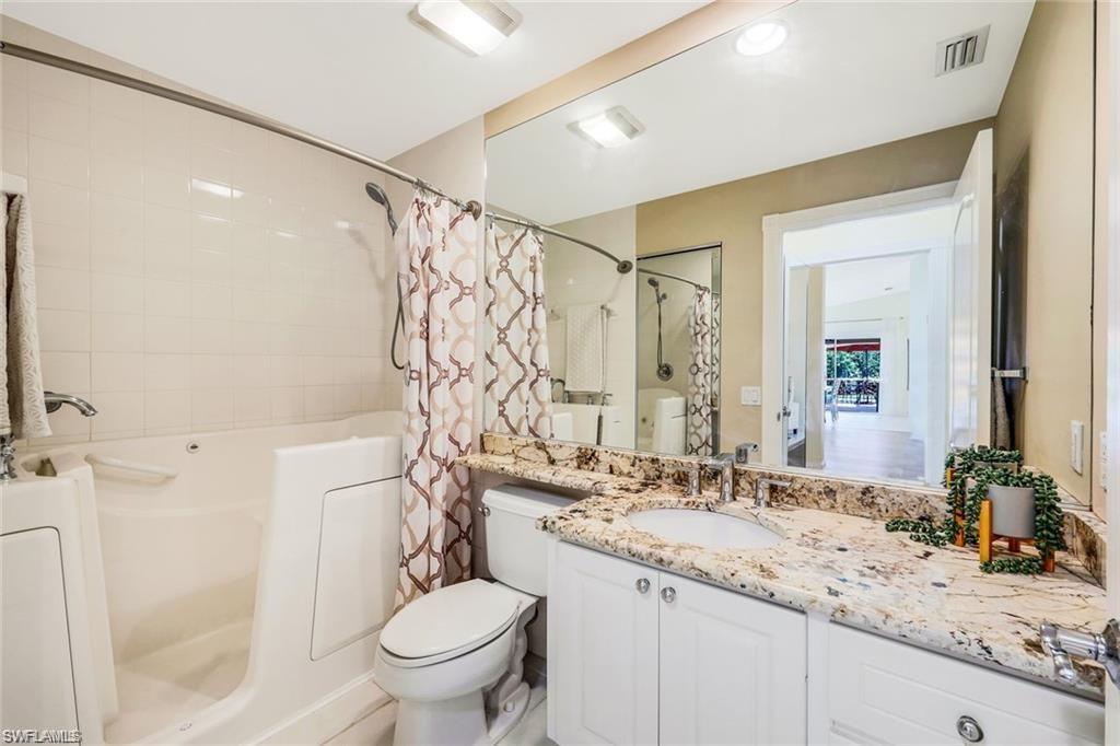 4823 Lasqueti Way Naples, FL 34119 - Photo 12 of 35 a bathroom with a granite countertop sink a toilet and shower