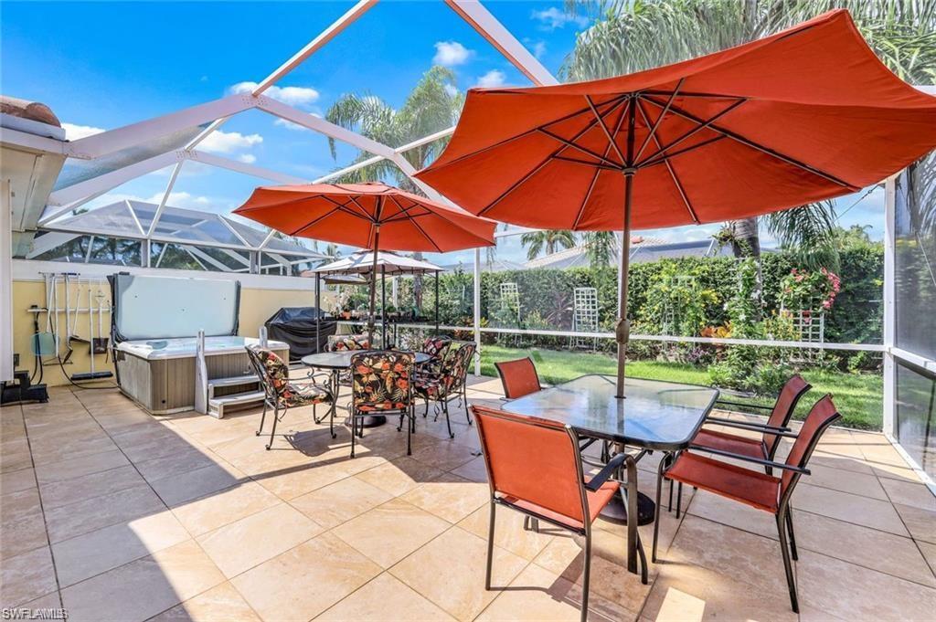 4823 Lasqueti Way Naples, FL 34119 - Photo 16 of 35 a view of a patio with a table and chairs under an umbrella