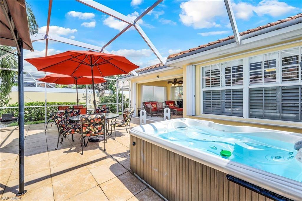 4823 Lasqueti Way Naples, FL 34119 - Photo 18 of 35 a view of a patio with a table and chairs under an umbrella