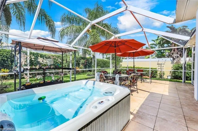 a view of a patio with a table and chairs under an umbrella