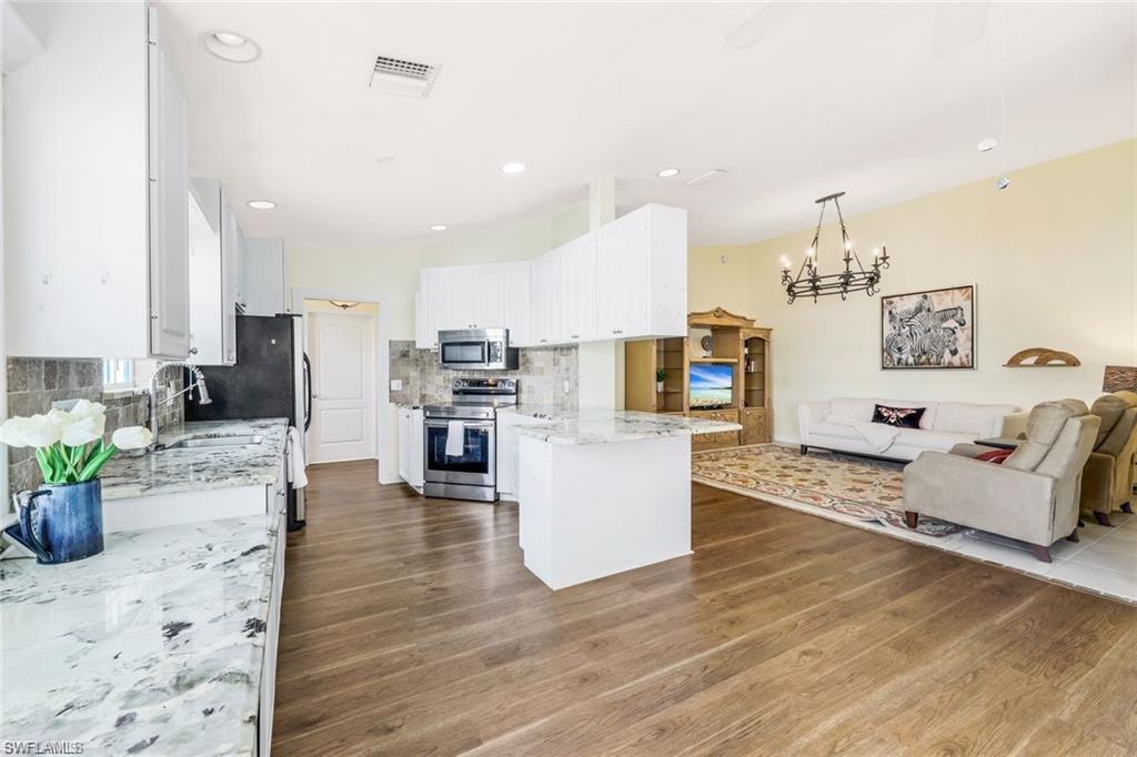 4823 Lasqueti Way Naples, FL 34119 - Photo 35 of 35 a living room with furniture and a wooden floor