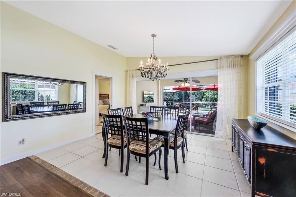 4823 Lasqueti Way Naples, FL 34119 - Photo 6 of 35 a view of a dining room with furniture and chandelier
