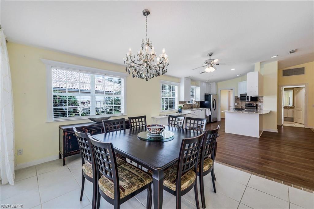 4823 Lasqueti Way Naples, FL 34119 - Photo 7 of 35 a view of a dining room with furniture window and wooden floor