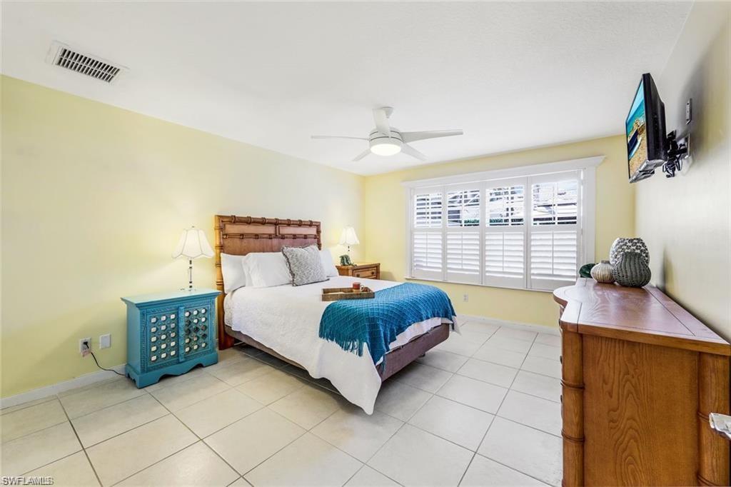 4823 Lasqueti Way Naples, FL 34119 - Photo 8 of 35 a spacious bedroom with a bed and a window