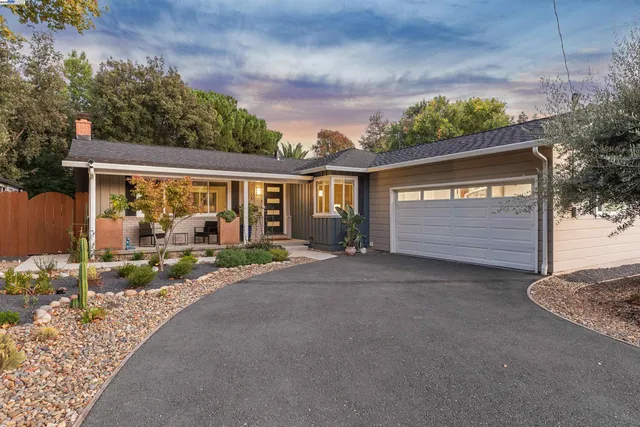 a view of a house with a yard and potted plants