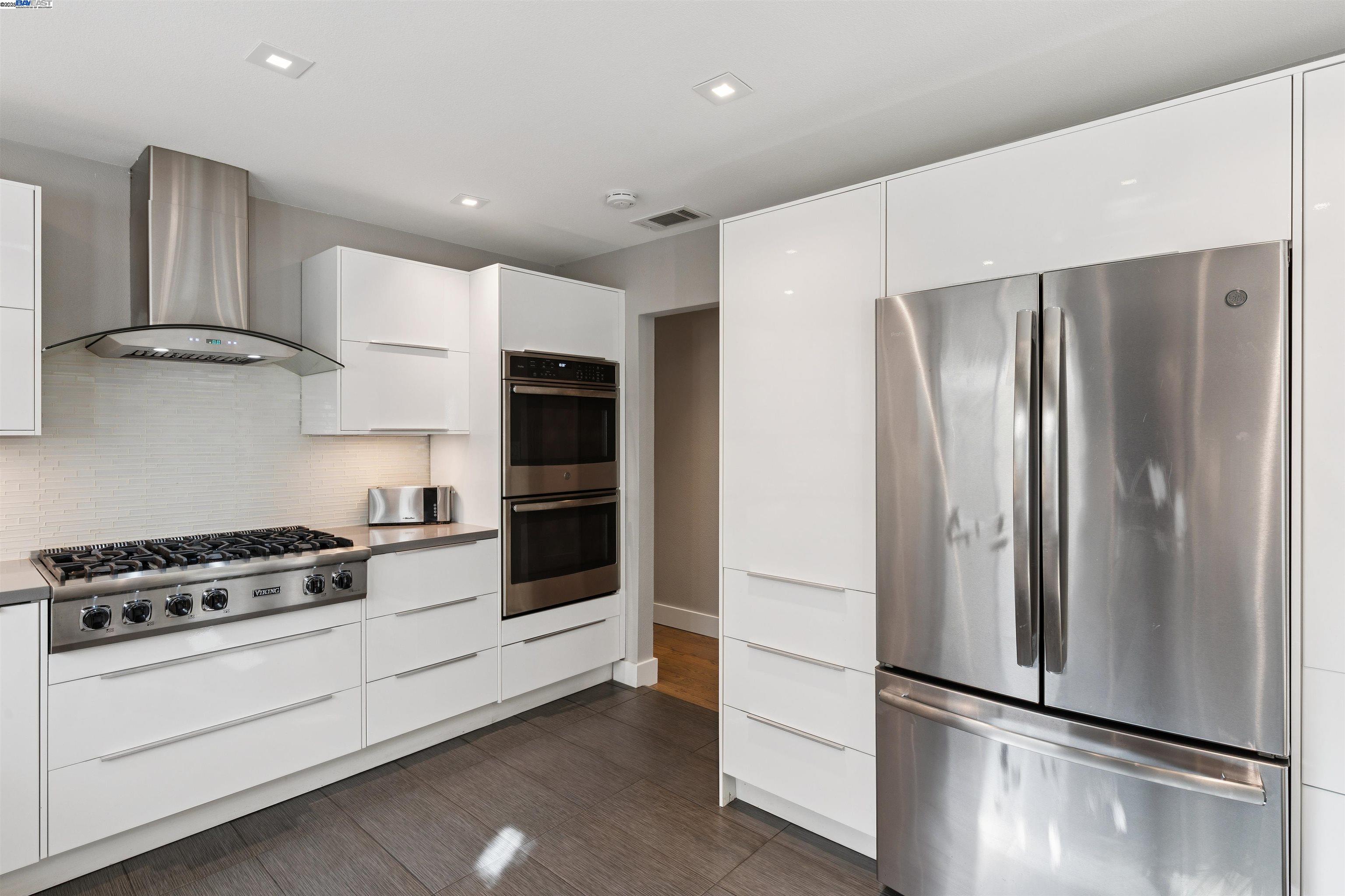 1230 Hale Drive Concord, CA 94518 - Photo 18 of 60 a kitchen with stainless steel appliances a refrigerator a stove and white cabinets