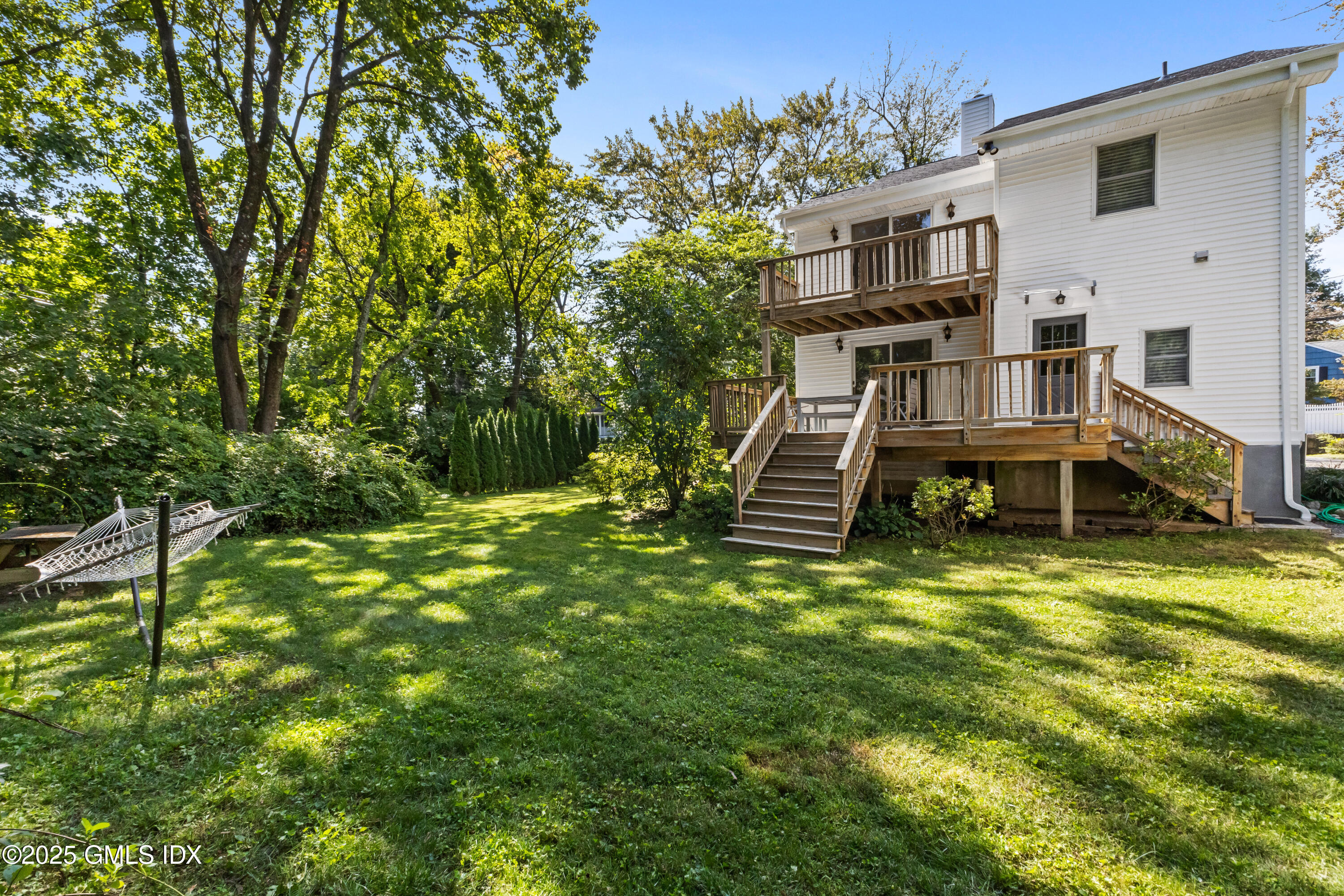 63 Riverside Avenue Riverside, CT 06878 - Photo 20 of 26 a backyard of a house with table and chairs