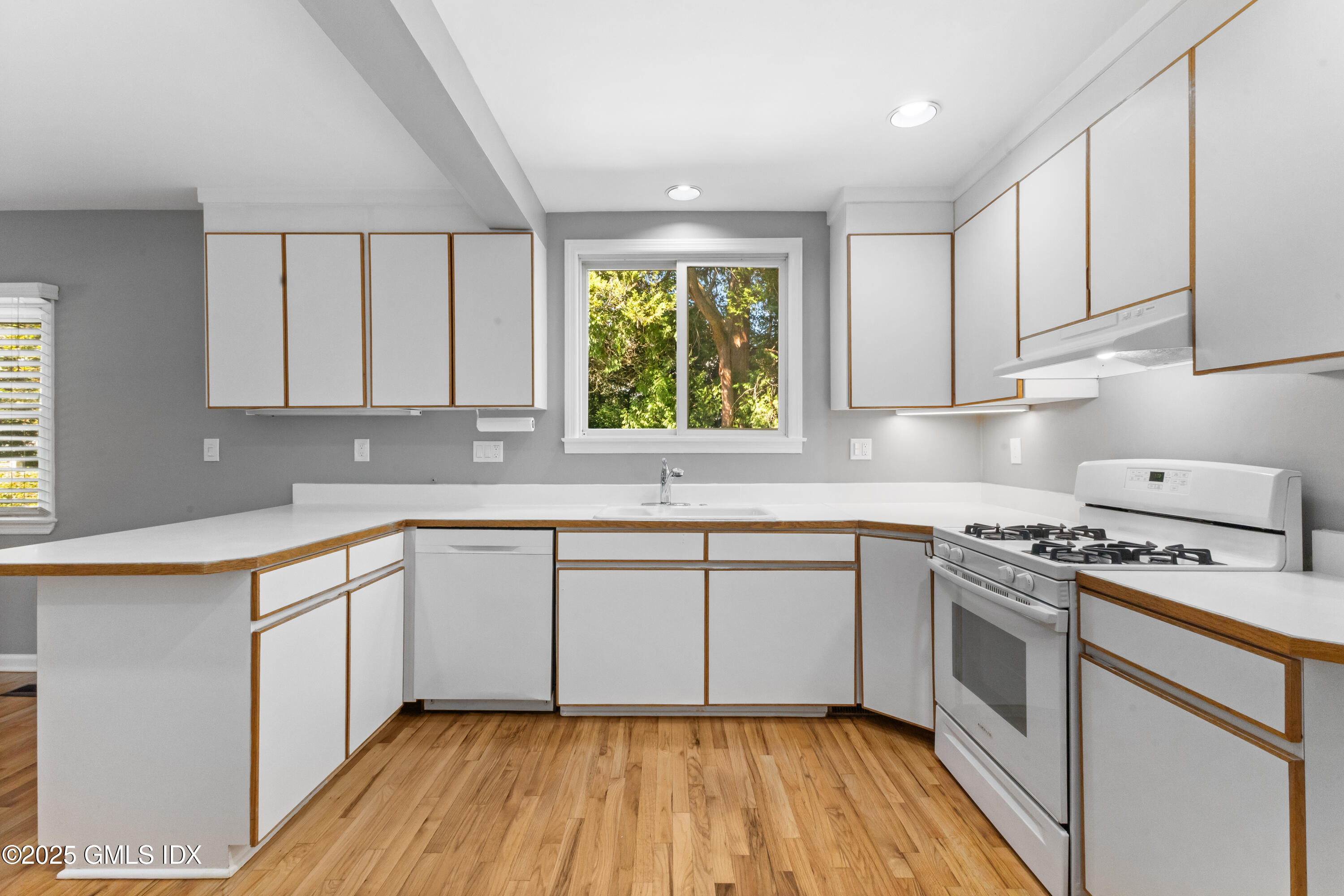 63 Riverside Avenue Riverside, CT 06878 - Photo 7 of 26 a kitchen with a white cabinets a sink dishwasher and a stove with wooden floor