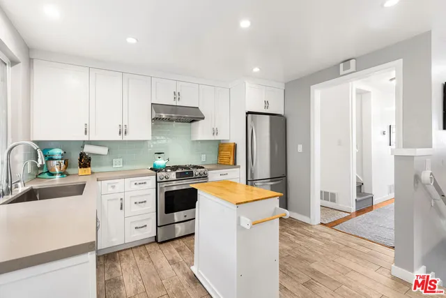 a kitchen with stainless steel appliances kitchen island granite countertop a stove a sink and a microwave