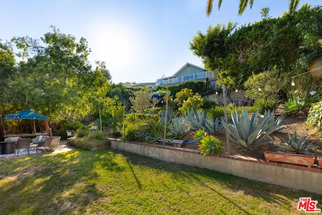 a view of a patio with table and chairs under an umbrella