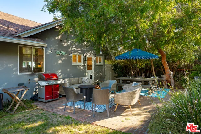 an outdoor sitting area with furniture and umbrella