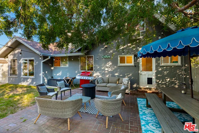 a wooden bench sitting in backside of a house with a yard