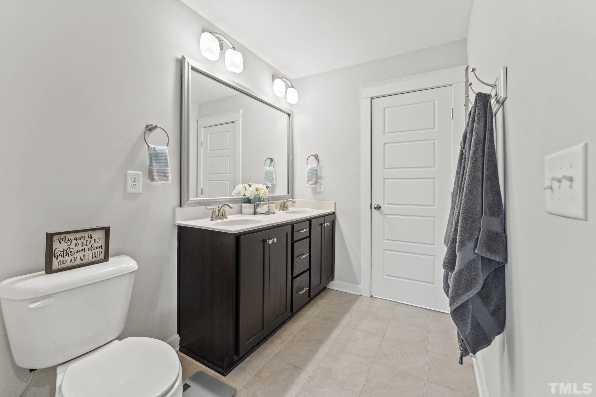 6329 Pesta Court Raleigh, NC 27612 - Photo 13 of 25 a bathroom with a toilet sink vanity and mirror