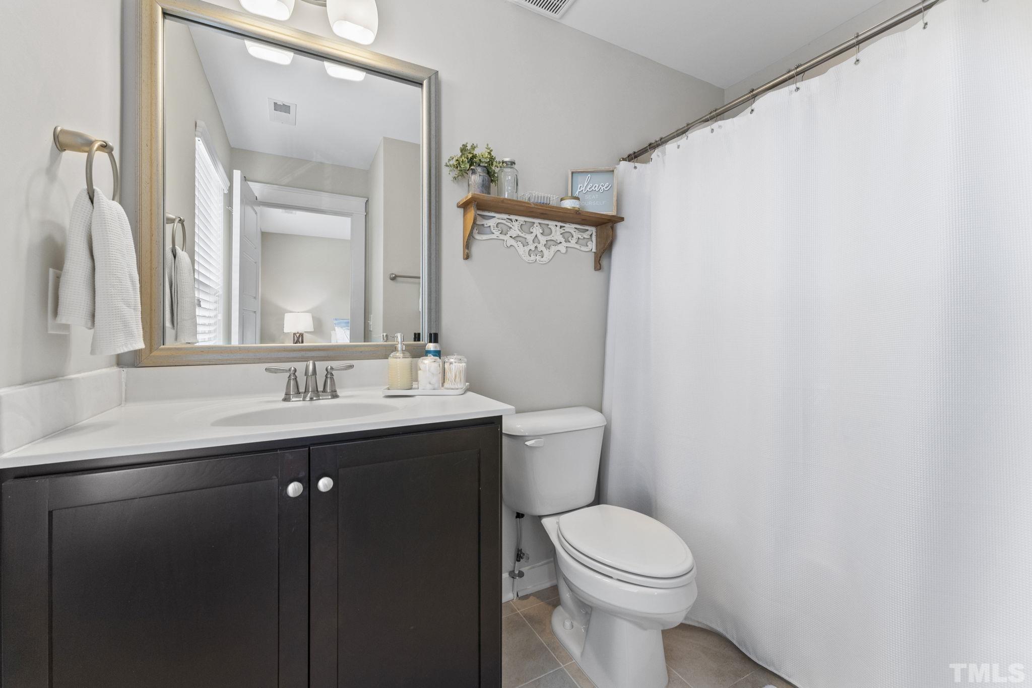 6329 Pesta Court Raleigh, NC 27612 - Photo 17 of 25 a bathroom with a sink a toilet and a mirror