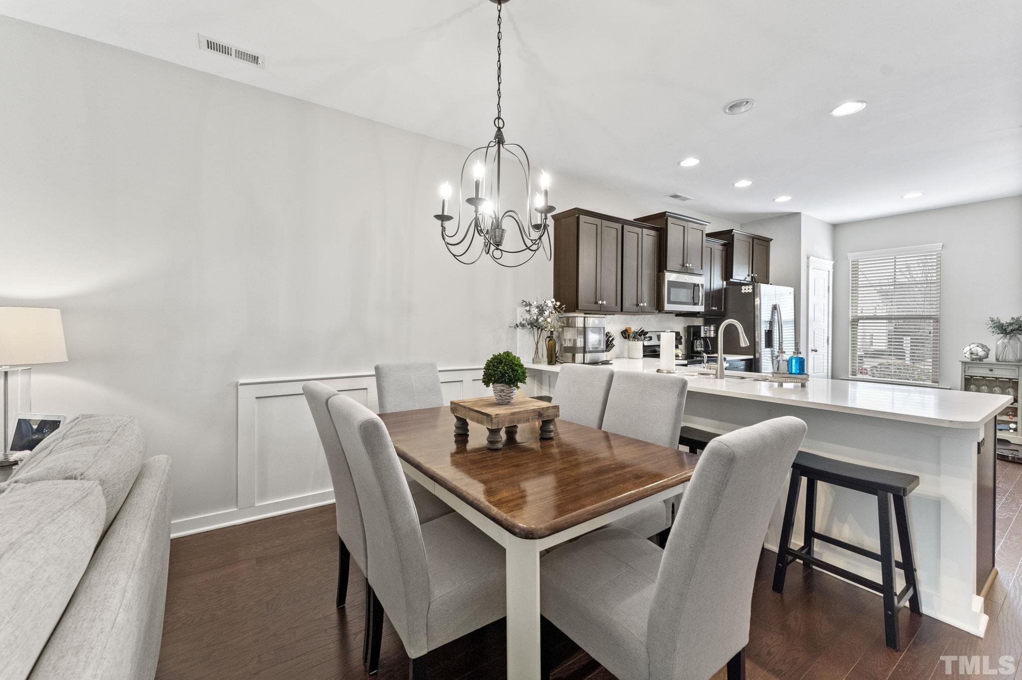 6329 Pesta Court Raleigh, NC 27612 - Photo 4 of 25 a view of a dining room with furniture a chandelier and wooden floor