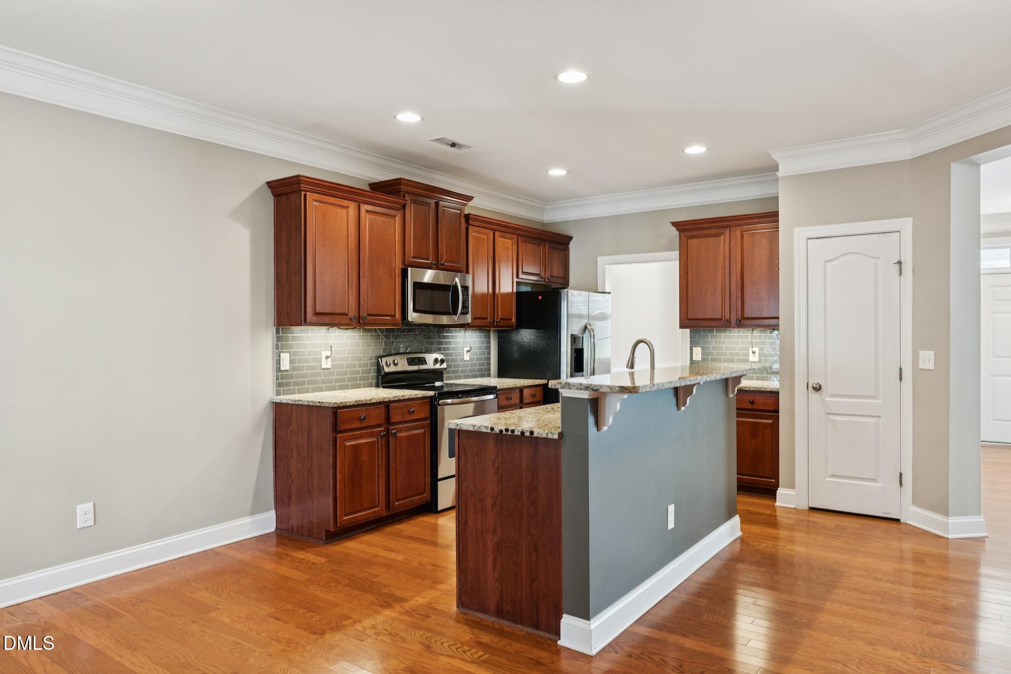 616 Democracy Street Raleigh, NC 27603 - Photo 21 of 61 a kitchen with stainless steel appliances granite countertop a stove top oven a sink a refrigerator and a microwave